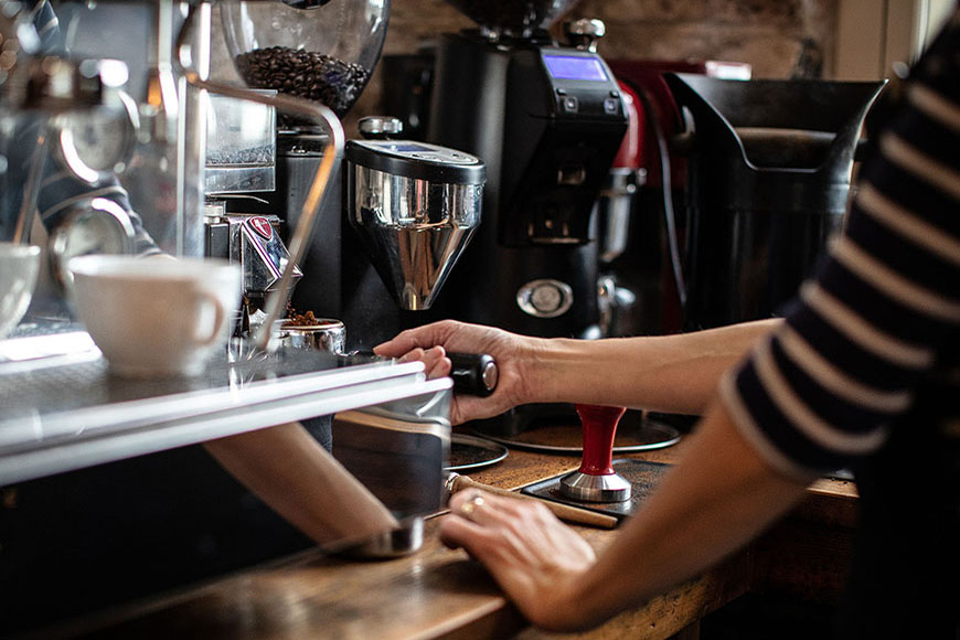 Grinding coffee beans on machine by Polly Baldwin Grinding coffee beans on machine by Polly Baldwin