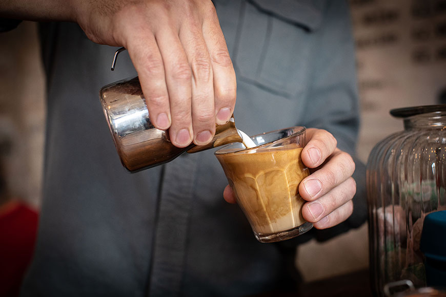 Pouring milk into a coffee cup by Polly Baldwin Pouring milk into a coffee cup by Polly Baldwin