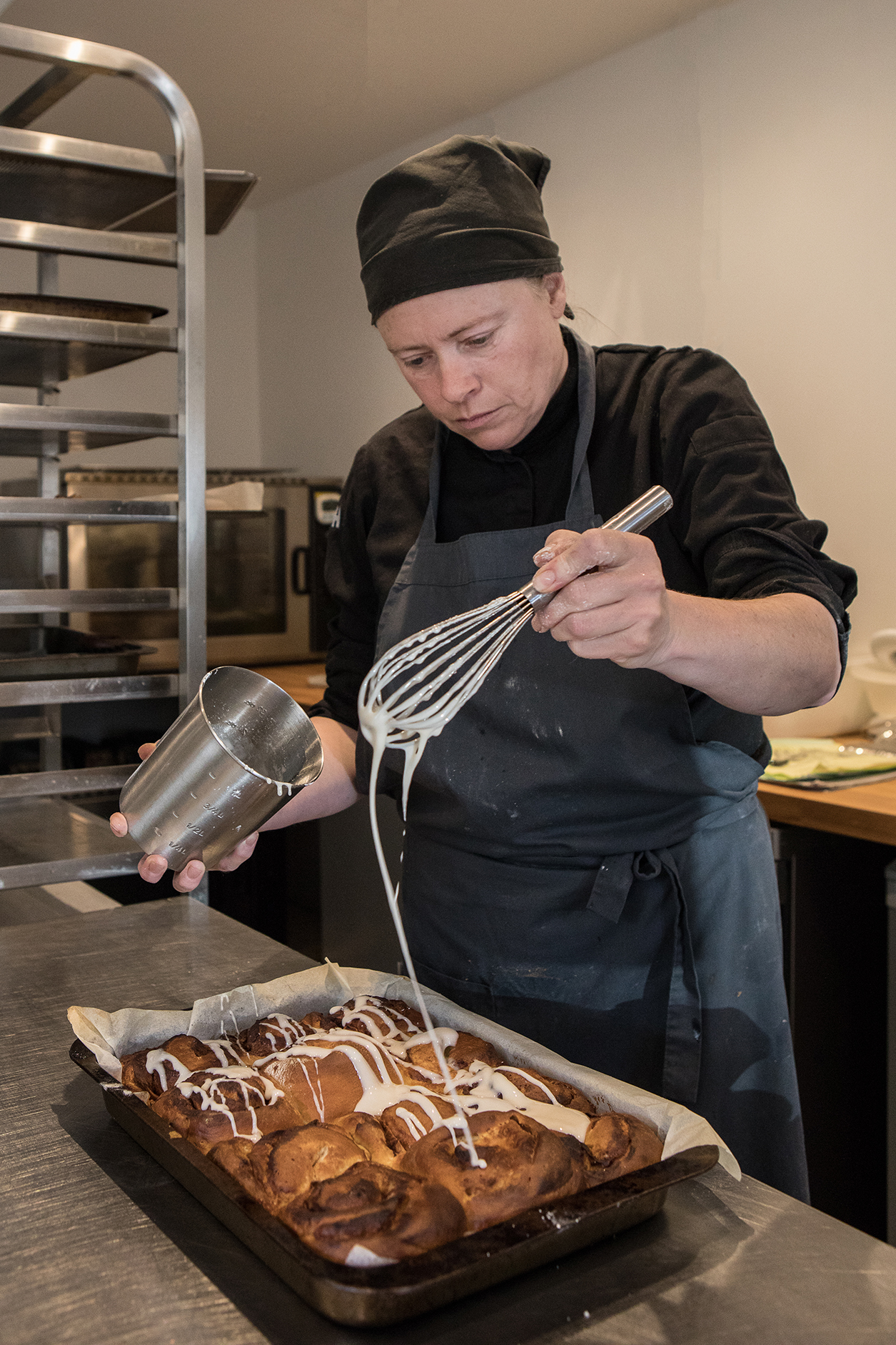 Emma icing cinnamon buns using a whisk by Polly Baldwin