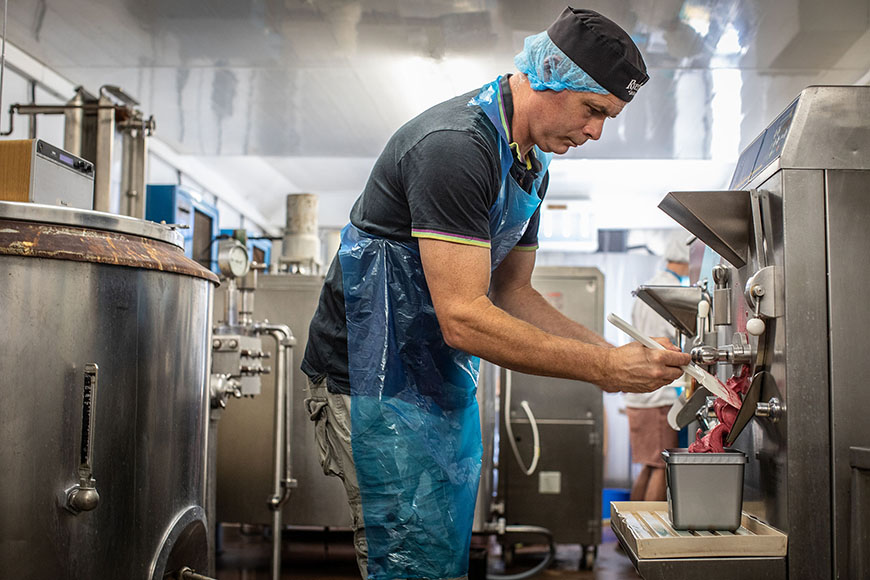 David scooping ice cream from machine into a tub by Polly Baldwin