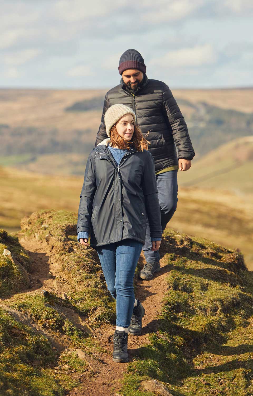Man and a woman walking through a moorland landscape. Credit Olivia Brabbs Photography.