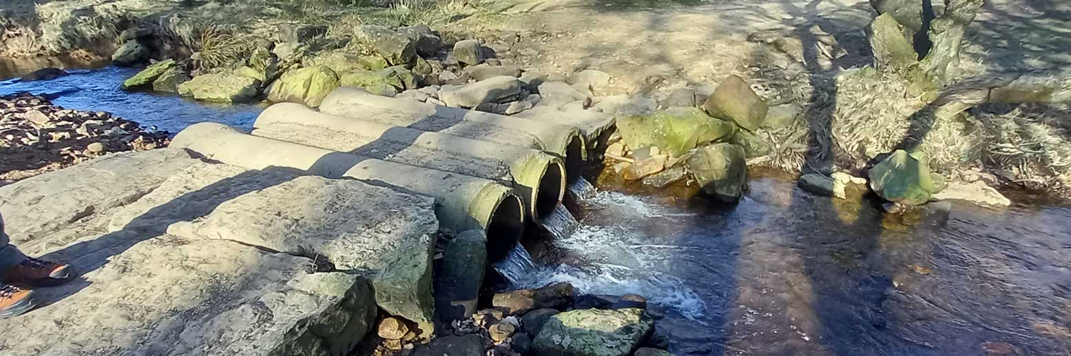 Three large pipes in a river