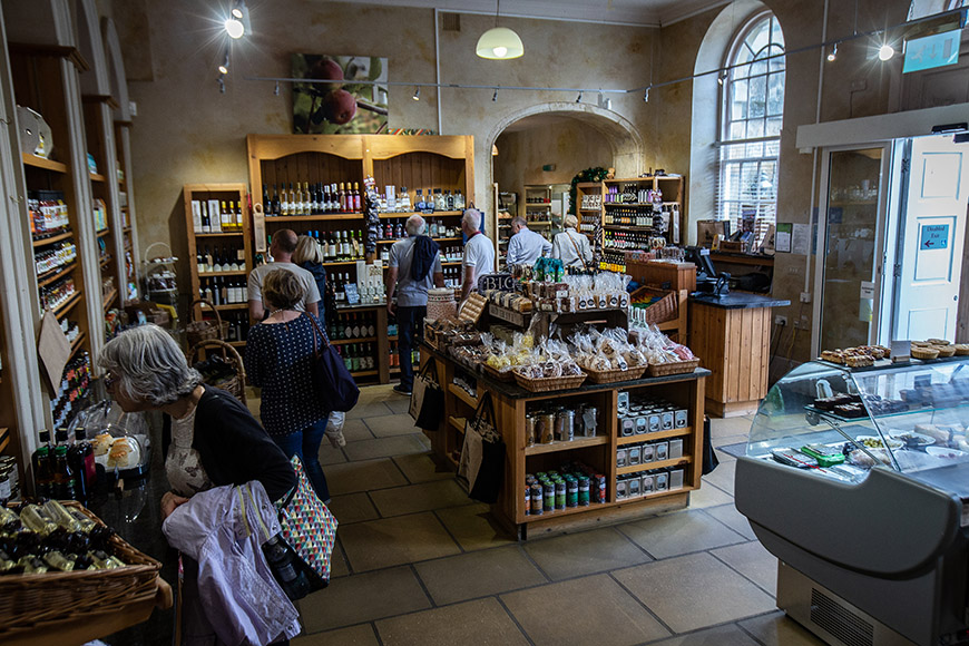 Inside farm shop with lots of people perusing by Polly Baldwin