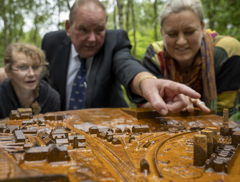 Close up of people looking at a cast model among a woodland in Grosmont. Close up of people looking at a cast model among a woodland in Grosmont.