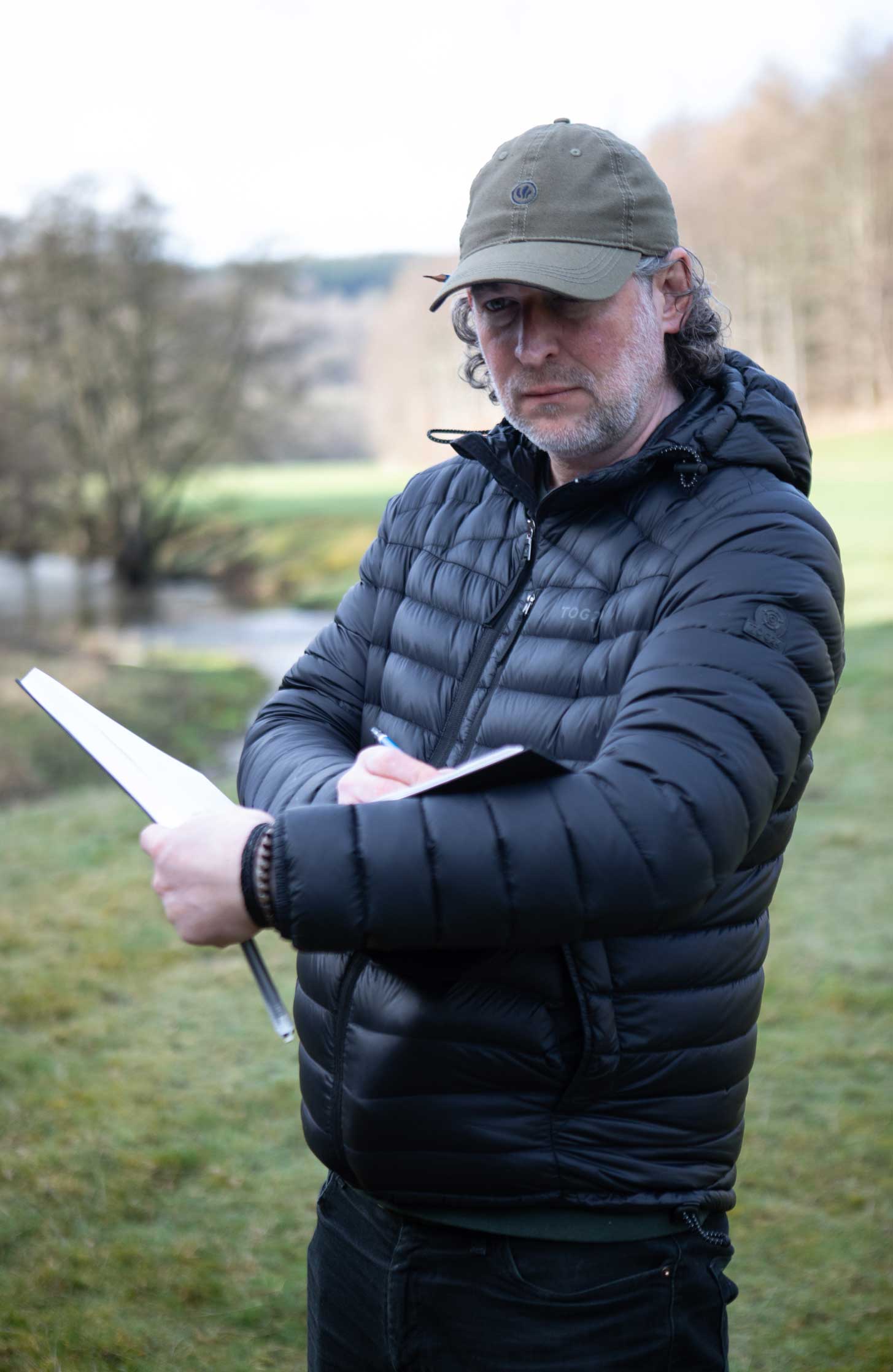 Photo of illustrator Nick Ellwood drawing in a field. Credit Charlie Fox.