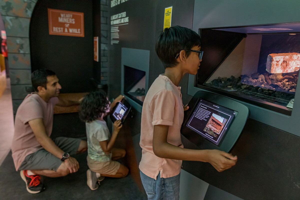 Family interacting with exhibition display. Credit Dependable Productions.