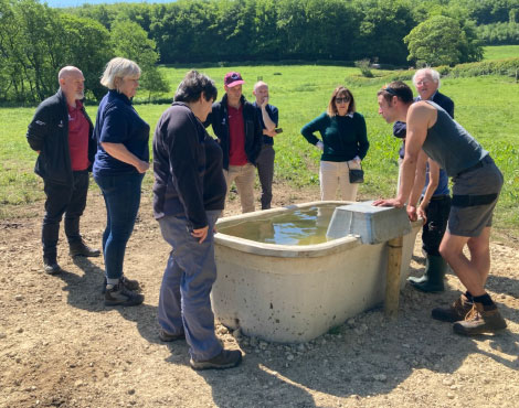 Group of people inspecting a water trough. Group of people inspecting a water trough.