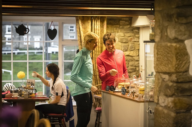 Two cyclist ordering tea and cake by Russell Burton