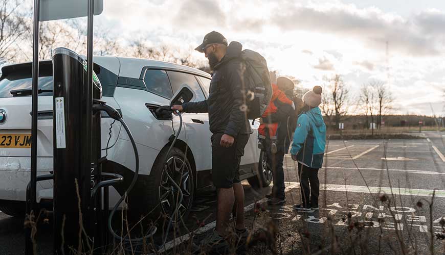 Family stood next to car in car park