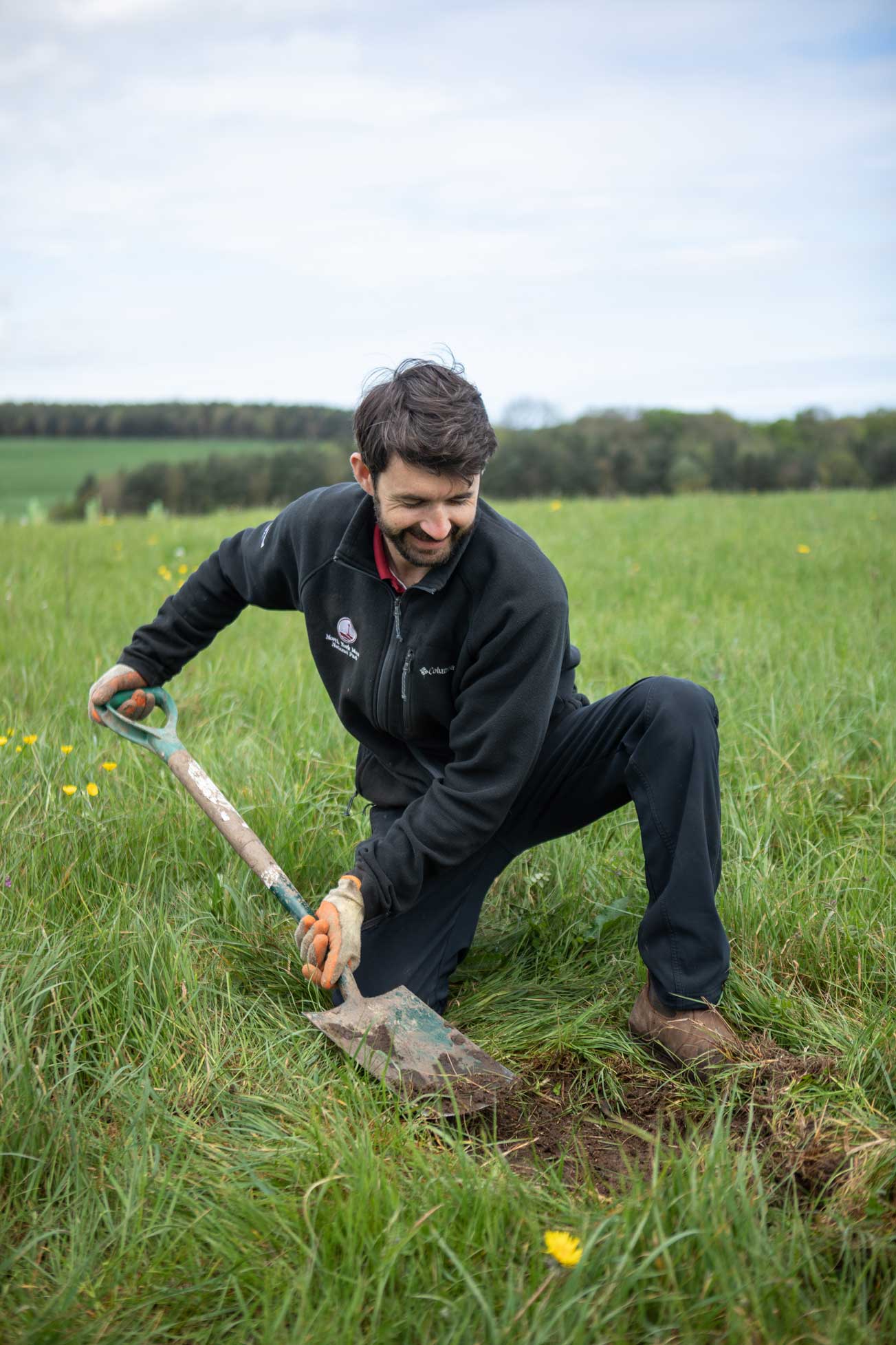 Man digging away grass from the top of the soil. Credit Charlie Fox. Man digging away grass from the top of the soil. Credit Charlie Fox.
