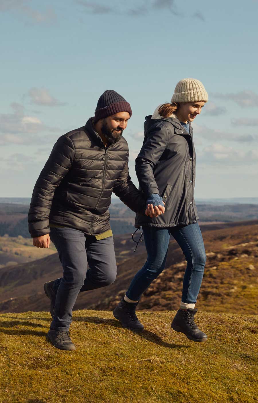 Man and a woman holding hands whilst walking through a moorland landscape. Credit Olivia Brabbs Photography. Man and a woman holding hands whilst walking through a moorland landscape. Credit Olivia Brabbs Photography.