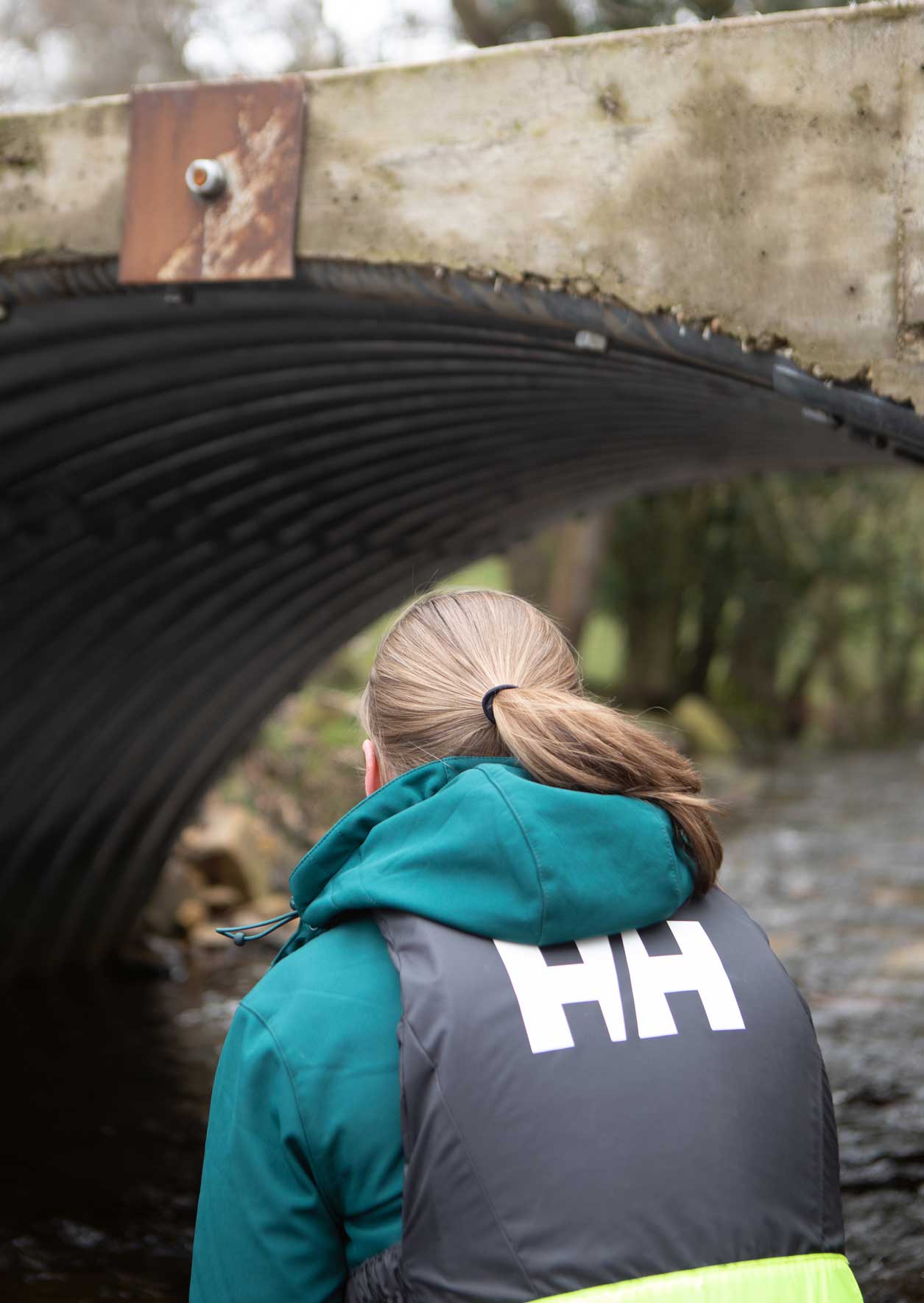 Female looking at a newly constructed small bridge over a river. Credit Charlie Fox.
