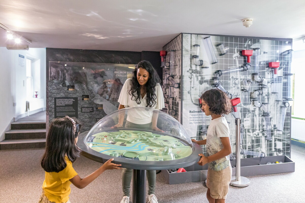 Mum and two daughters interacting with exhibition display. Credit Dependable Productions.