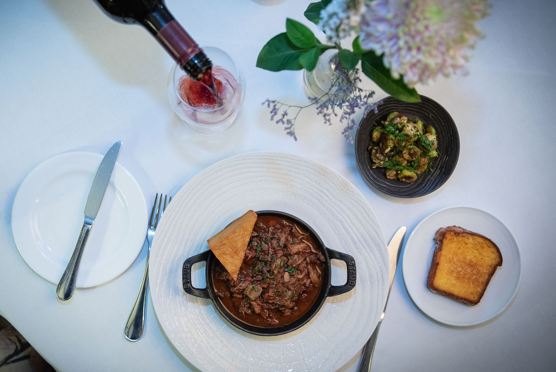 Plates of food and wine set on table by Polly Baldwin Plates of food and wine set on table by Polly Baldwin