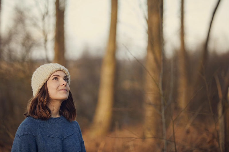 Female looking up in a reflective mood among a woodland. Credit Olivia Brabbs Photography.