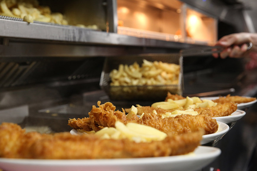 Plates of fish and chips in kitchen by Ceri Oakes Plates of fish and chips in kitchen by Ceri Oakes