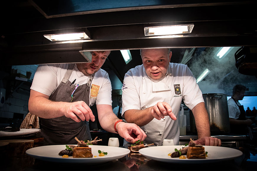 Andrew and chef stood over food to be served by Polly Baldwin Andrew and chef stood over food to be served by Polly Baldwin