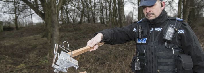 An officer demonstrates the power of an illegal pole trap