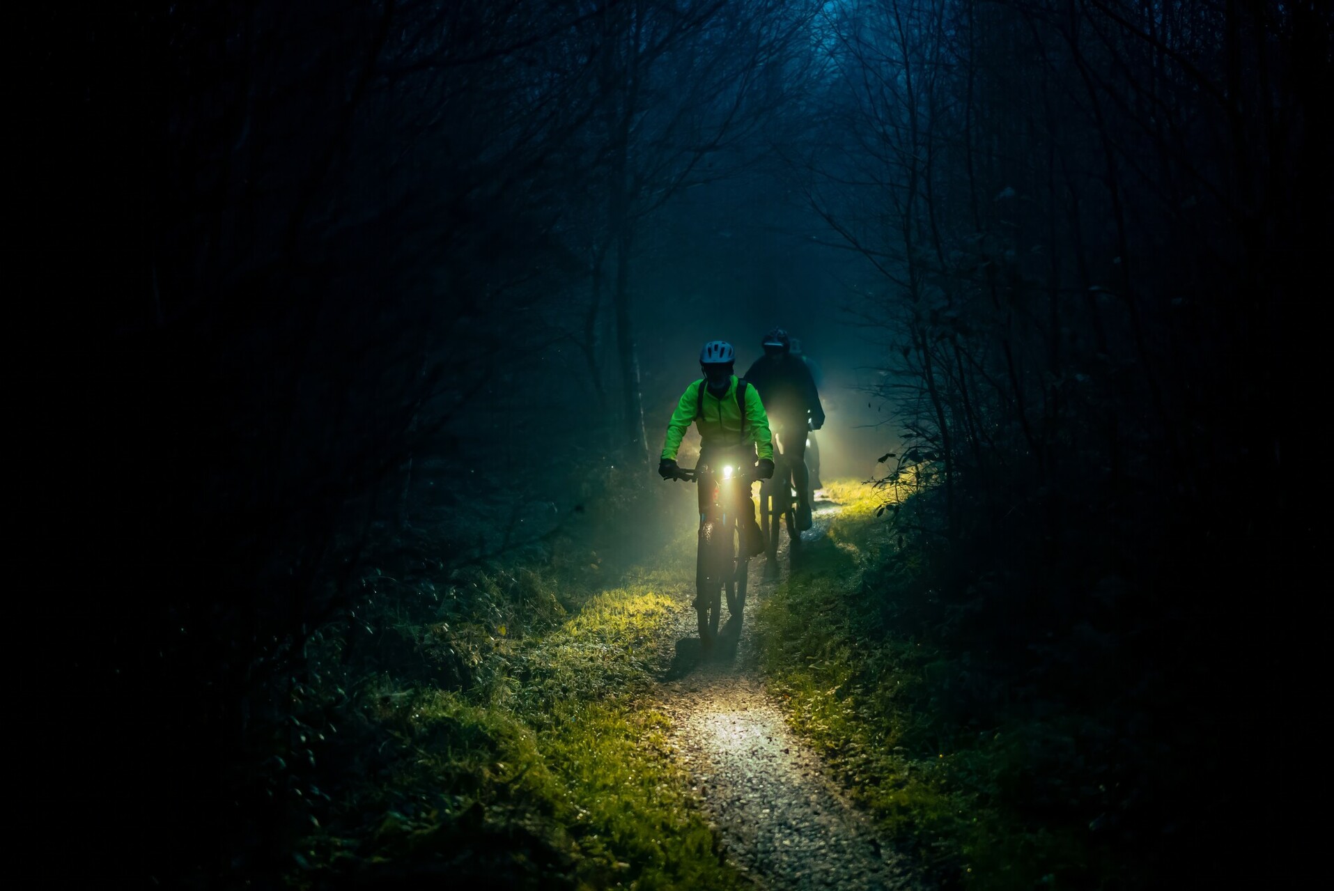 Cyclists riding at night by Hewitt & Walker