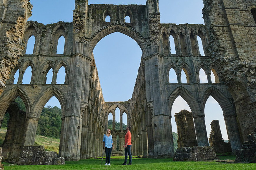 Man and woman at Rievaulx Abbey, woman is using a walking stick Credit VisitBritain Images/Daniel Wildey Man and woman at Rievaulx Abbey, woman is using a walking stick Credit VisitBritain Images/Daniel Wildey