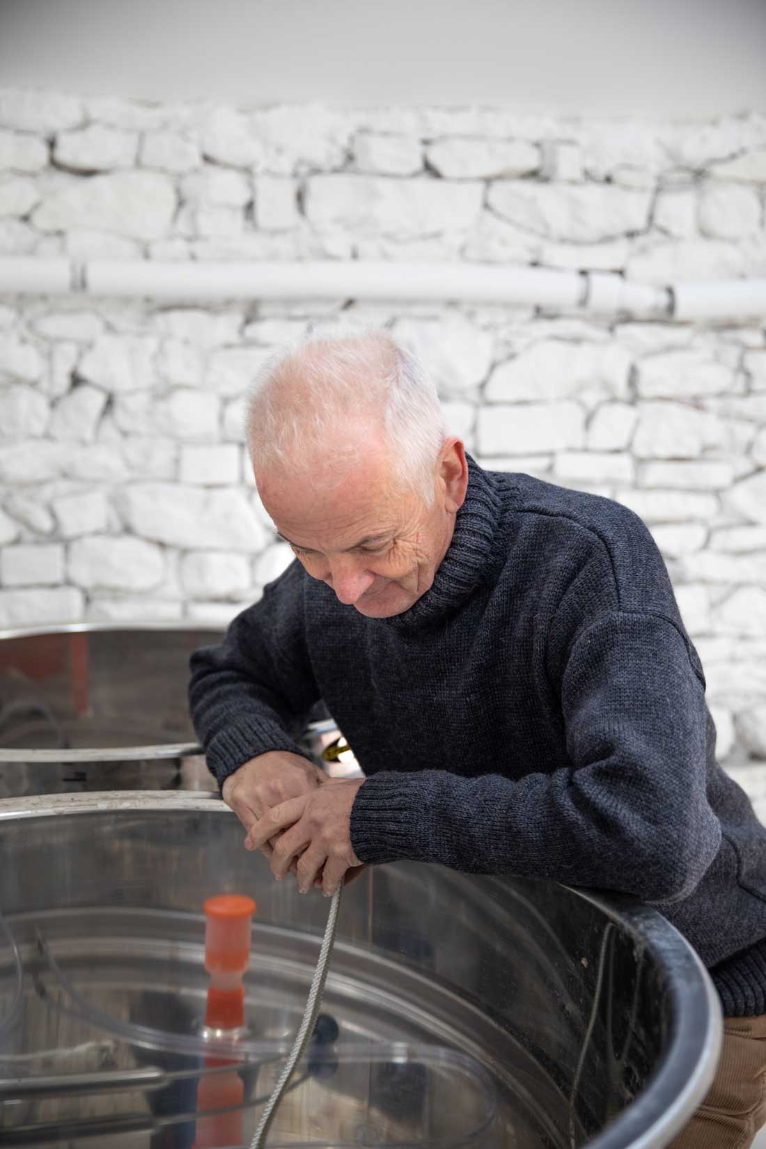 Man looking at large steel equipment used in cider production. Credit Charlie Fox.