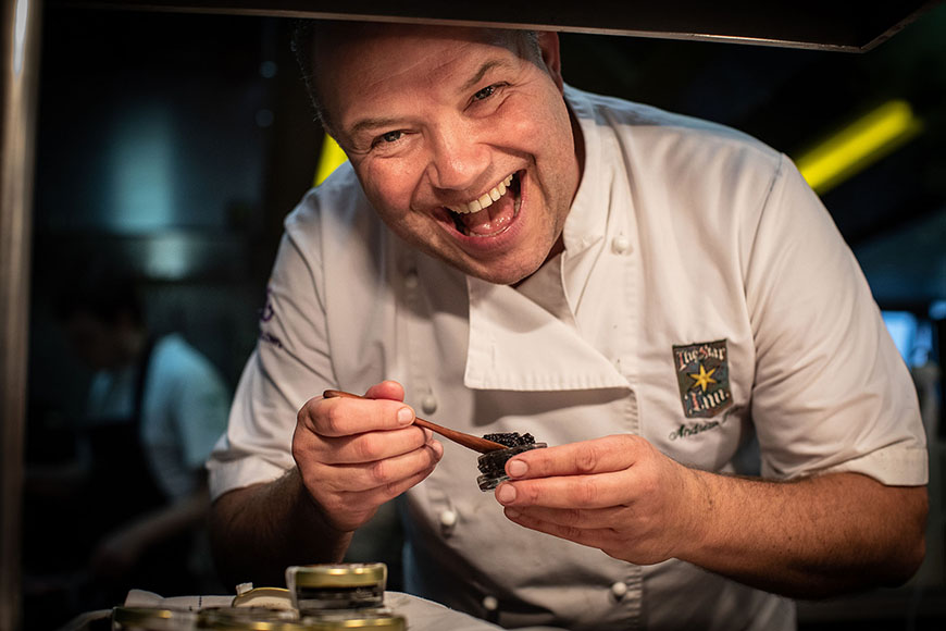 Andrew smiling whilst plating up by Polly Baldwin
