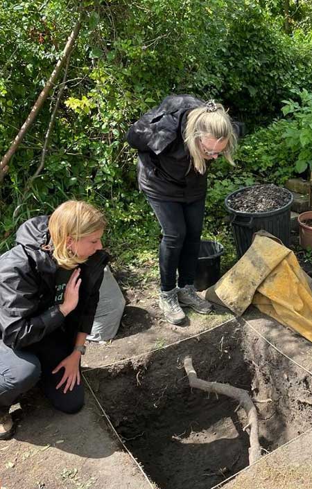 Four people inspecting archaeological hole. Four people inspecting archaeological hole.