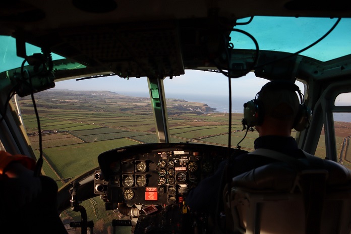 A view of the coastline can be seen from the inside of a helicopter 