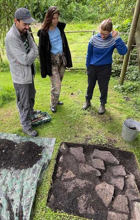 Four people inspecting archaeological hole. Four people inspecting archaeological hole.