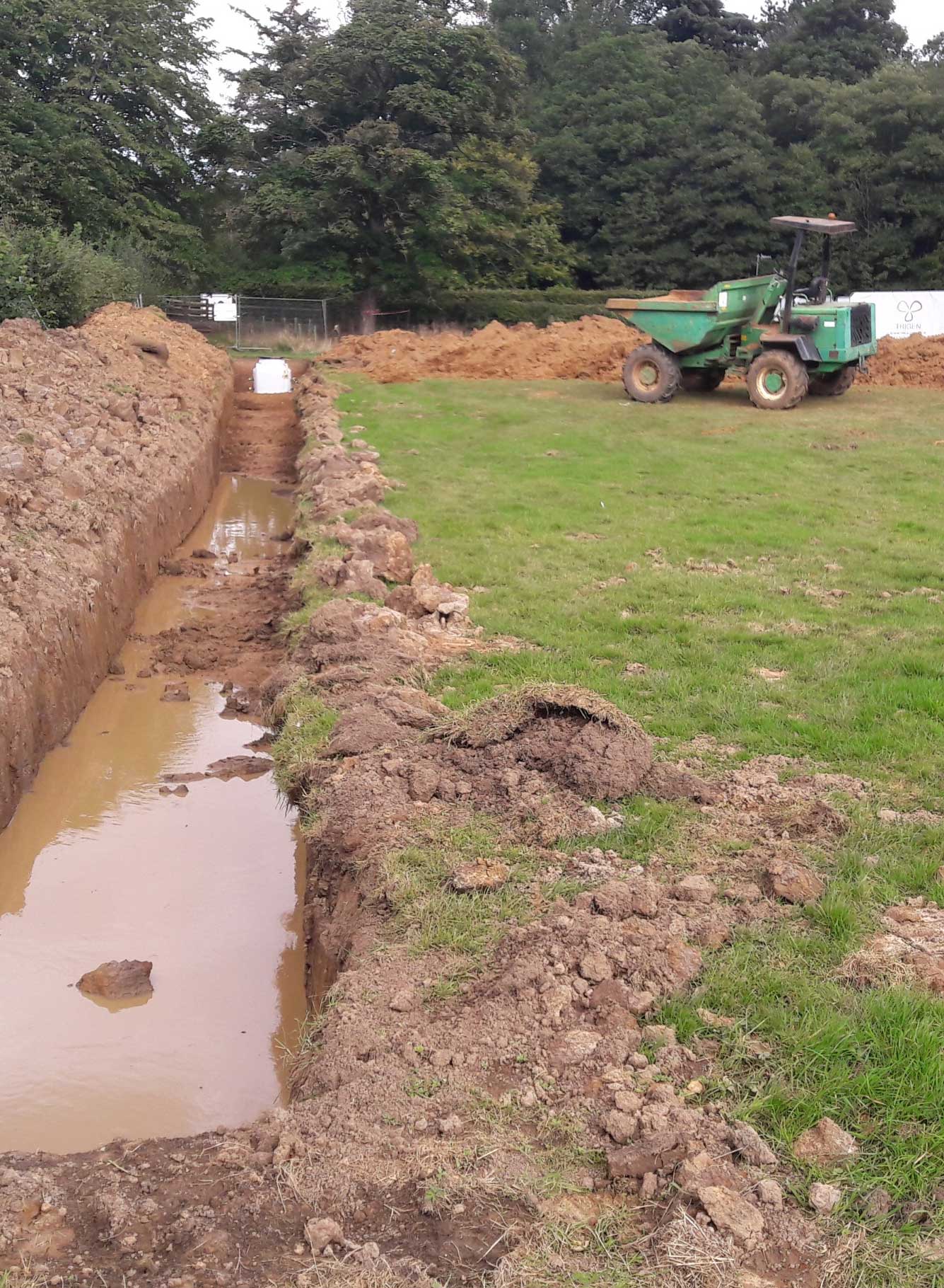 New excavated trenches in a field for ground sourced heat pumps.