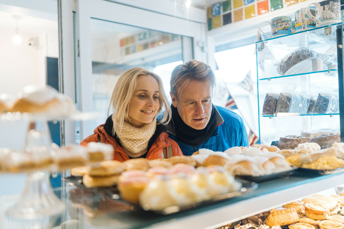 Two people looking at cakes in a bakery