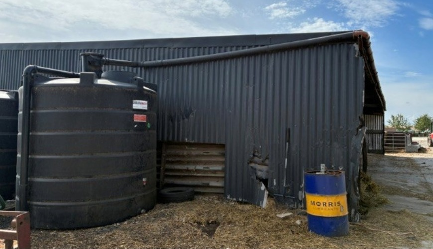 Water storage at Wethercote Farm Industrial storage tanks and pipes beside a grey corrugated-metal building under a blue sky.