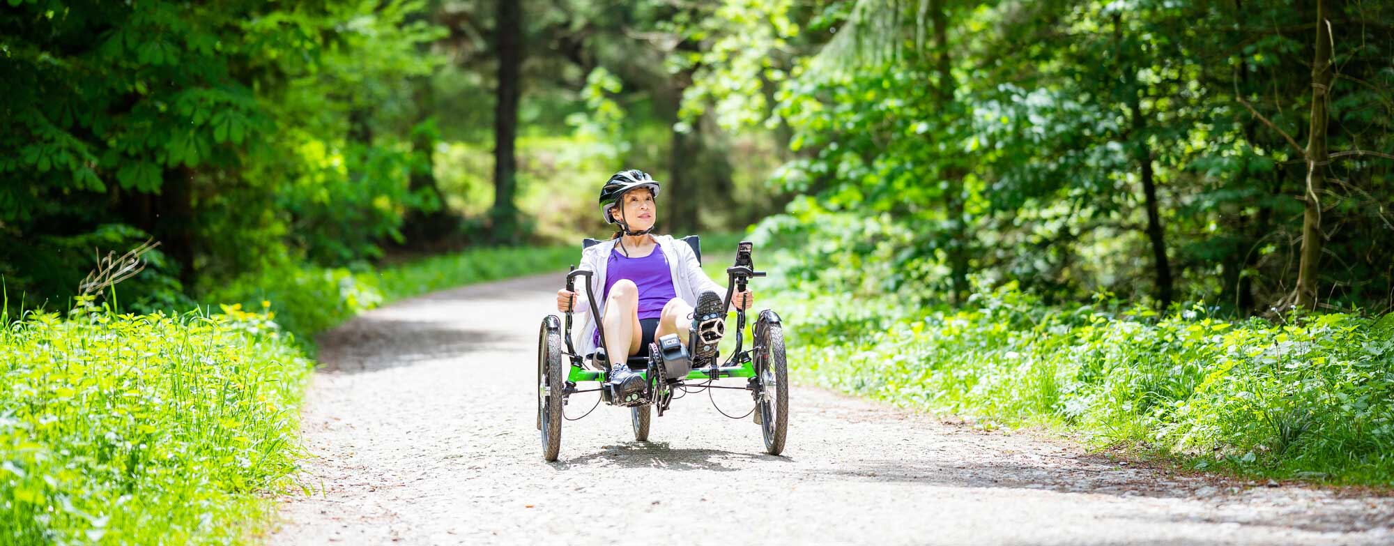 Female using a recumbent ebike in a forest setting. Credit Visit Britain/Peter Kindersley. 