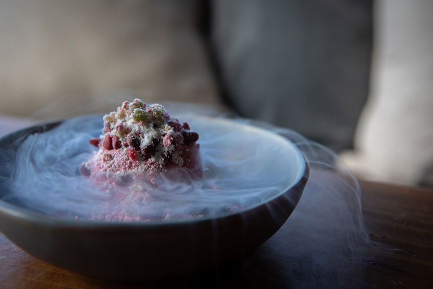 A dessert in a bowl with dry ice coming from it by Polly Baldwin
