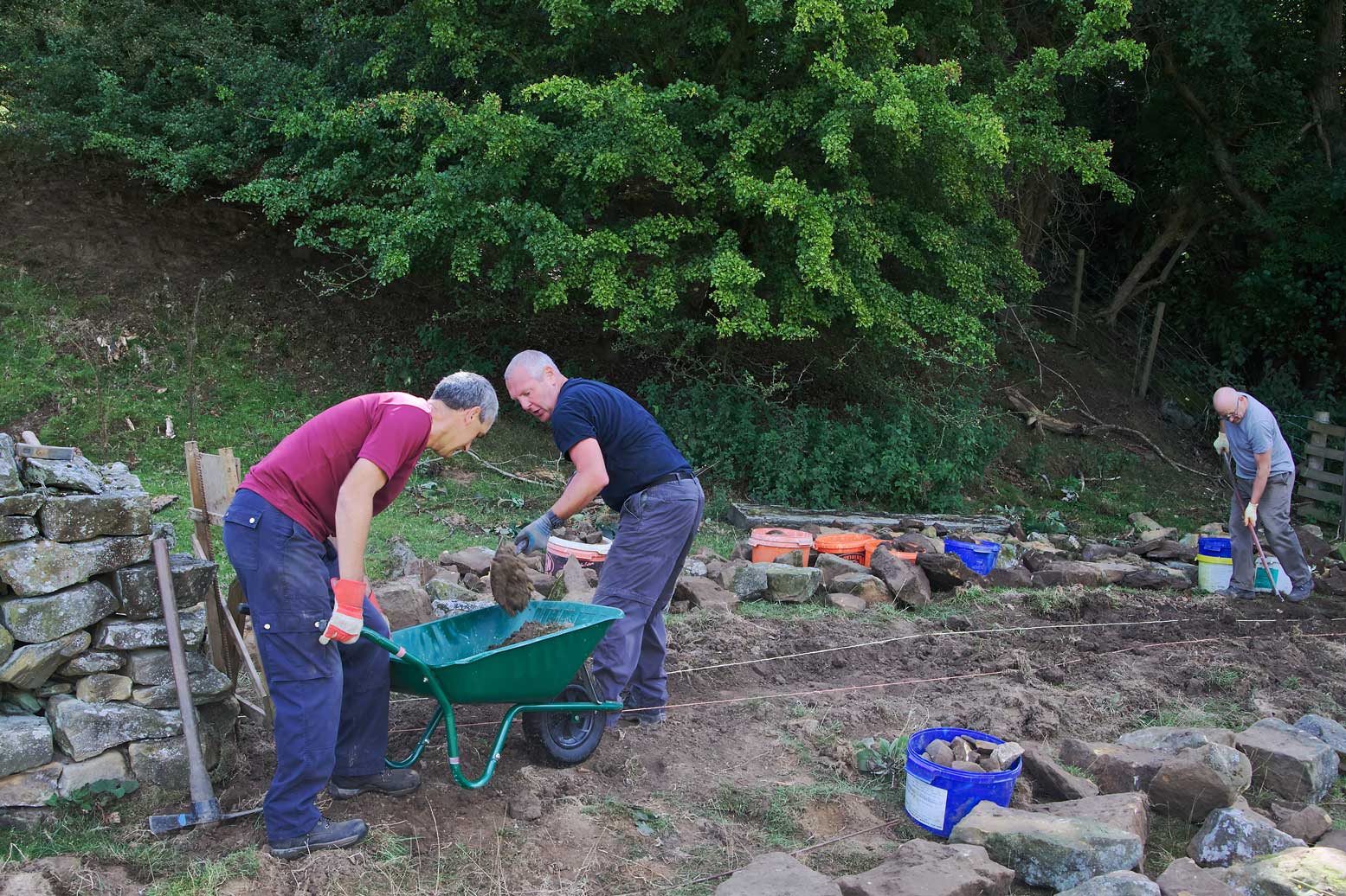 Volunteers carrying out dry stone wall repairs.