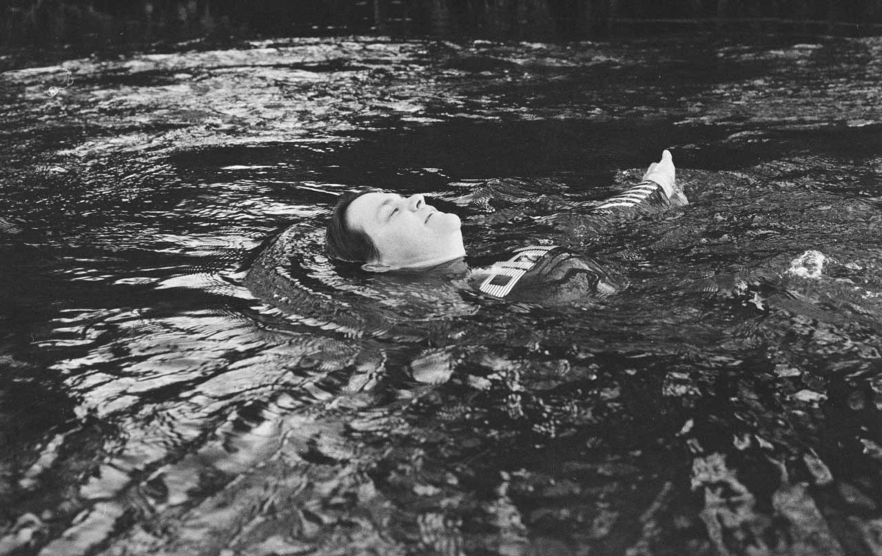 A woman floating in water. Black and white image.