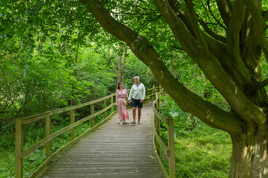 Two people walking on the boardwalk in grounds of Danby Lodge Credit Dependable Productions