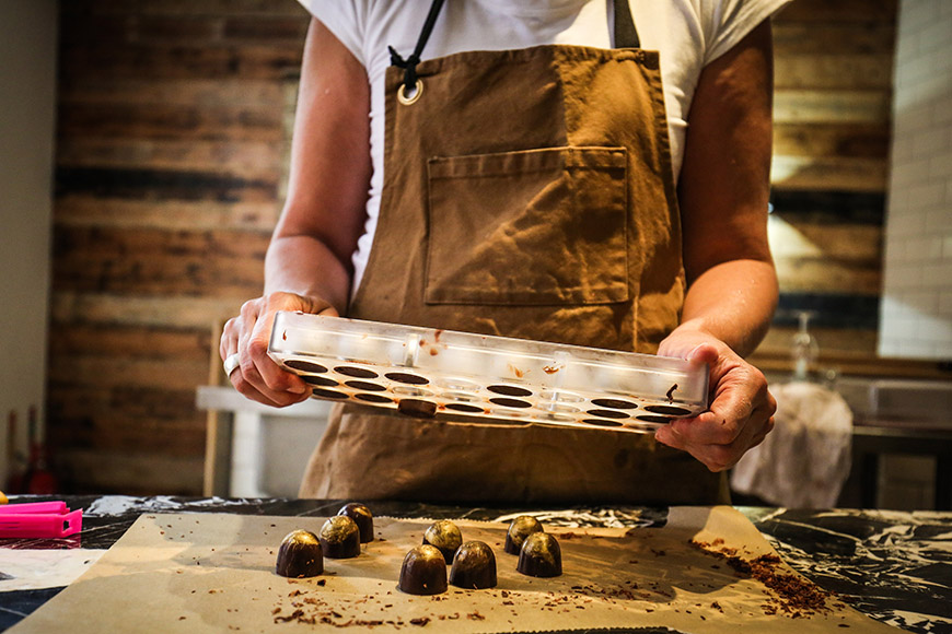 Chocolates being pushed out of the mould by Ceri Oakes Chocolates being pushed out of the mould by Ceri Oakes