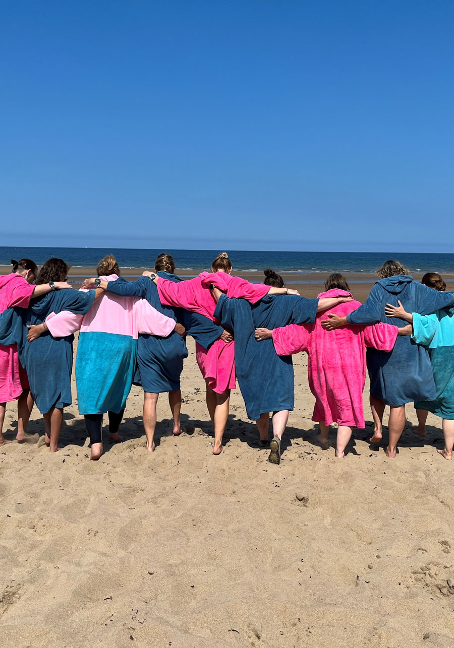 A group of women at the coast heading towards the sea A group of women at the coast heading towards the sea