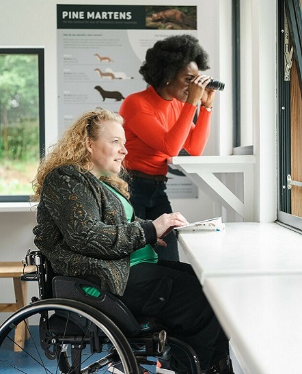 Two women birdwatching, from observatory, one using a wheelchair (c) VisitBritain/Peter Kindersley