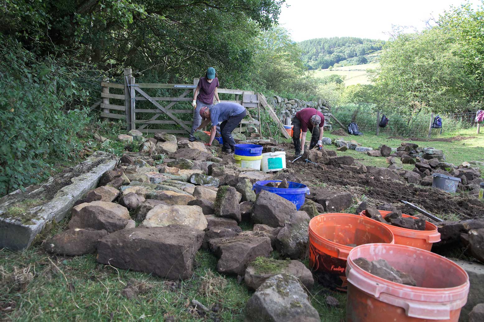 Volunteers carrying out dry stone wall repairs.