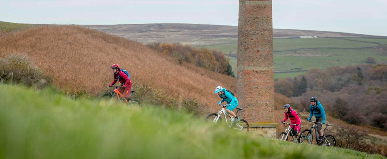 Four cyclists riding up a steep slope. Credit Russell Burton.