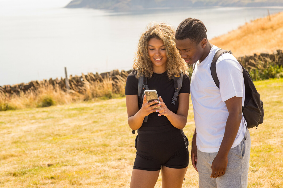 Young couple geocaching above Robin Hood's Bay