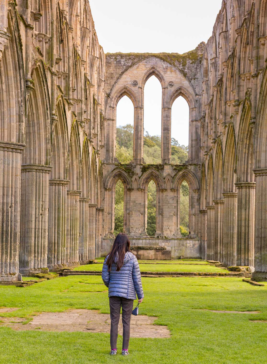 Female stood among the ruins of Rievaulx Abbey. Credit VisitEngland / Gary Walsh.