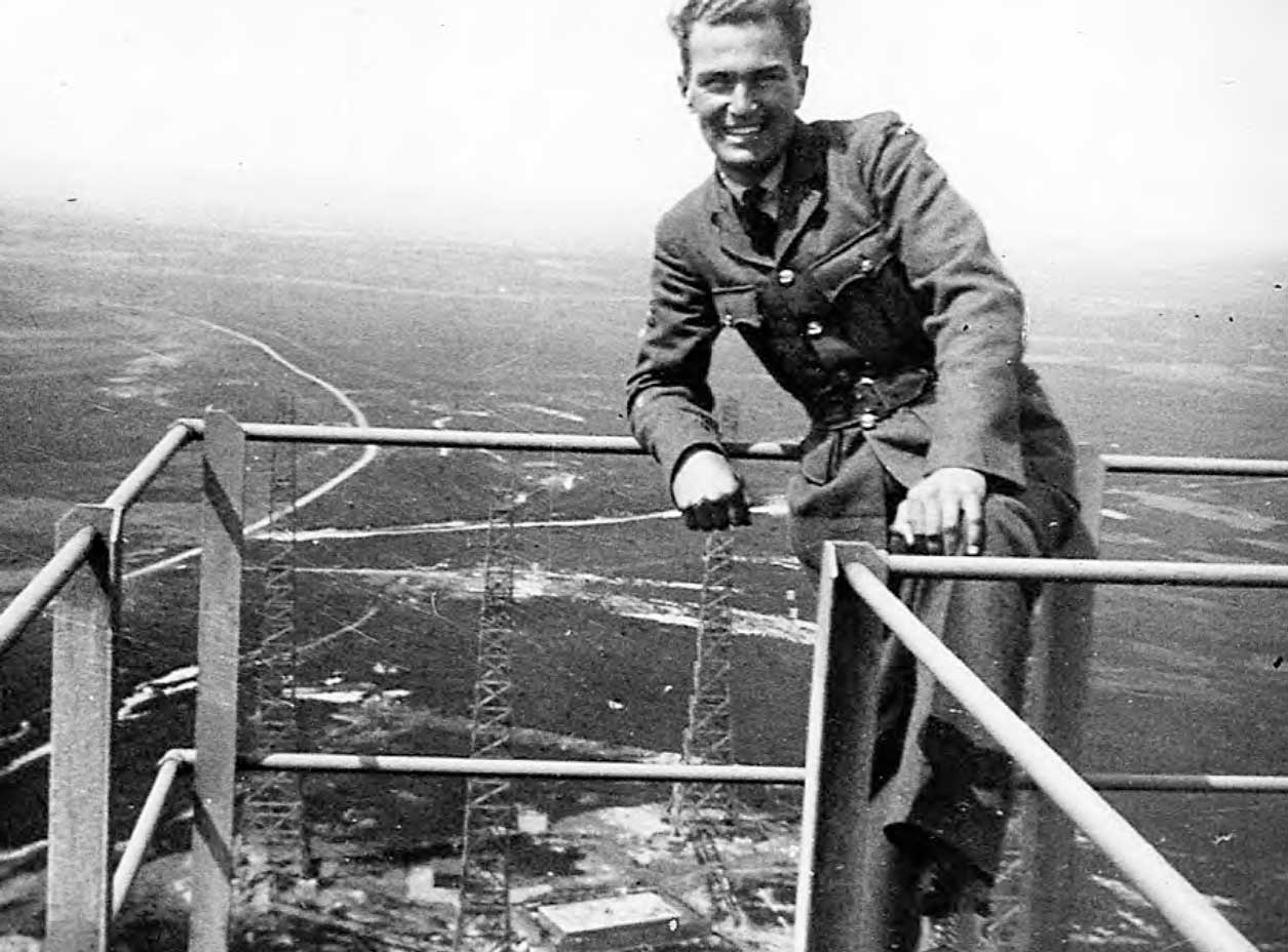 Man standing at the top of a very large metal structure. He is a radar mechanic for RAF Danby Beacon.