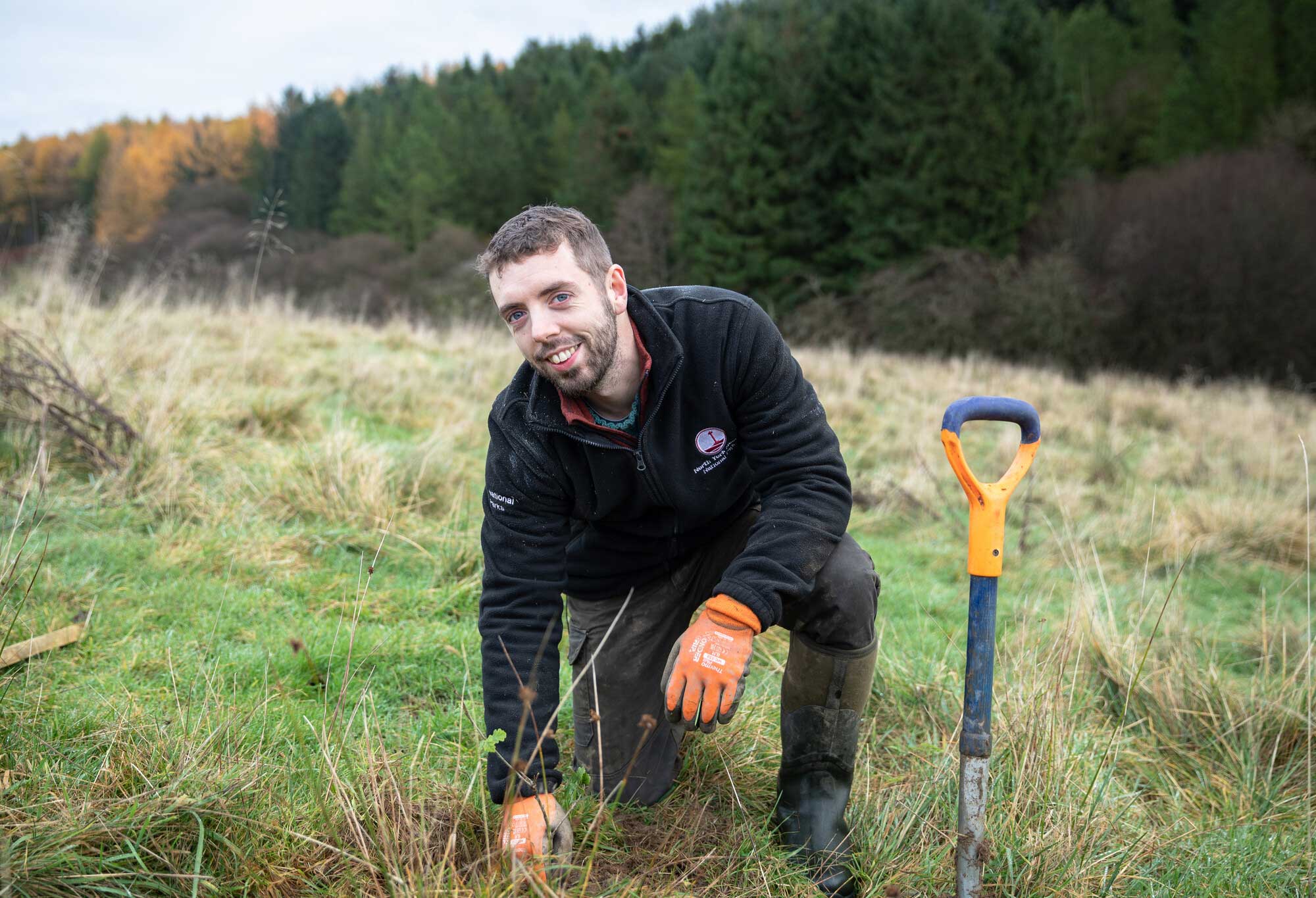 Woodland operation trainee Joseph planting a tree in a field. Credit Charlie Fox / NYMNPA.