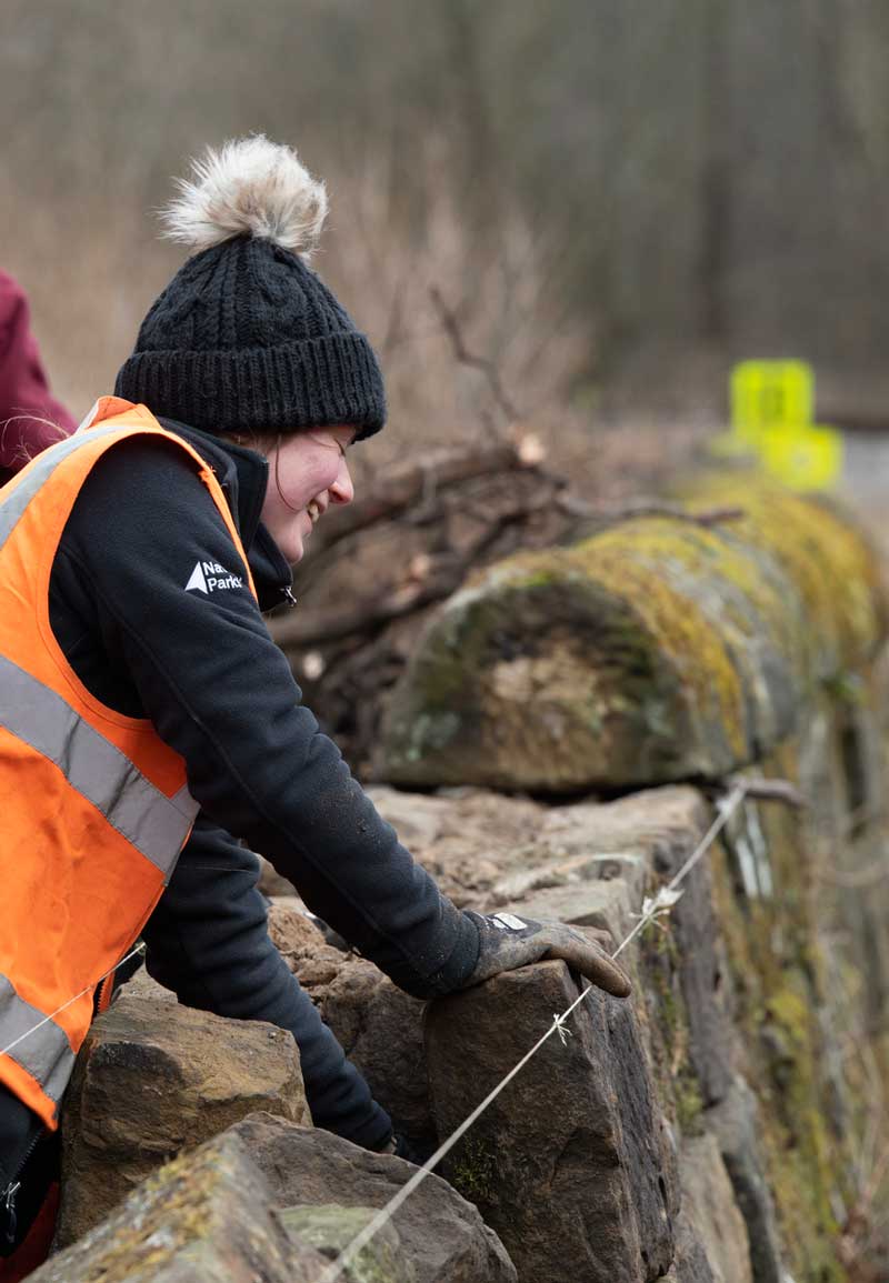 Female repairing dry stone wall. Credit Anglo American.