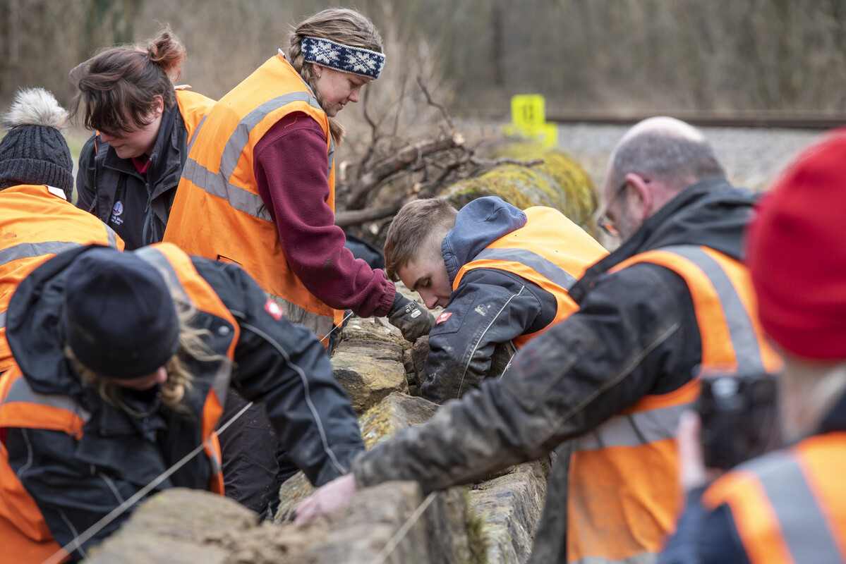 Group of people repairing a dry stone wall. Credit Anglo American.