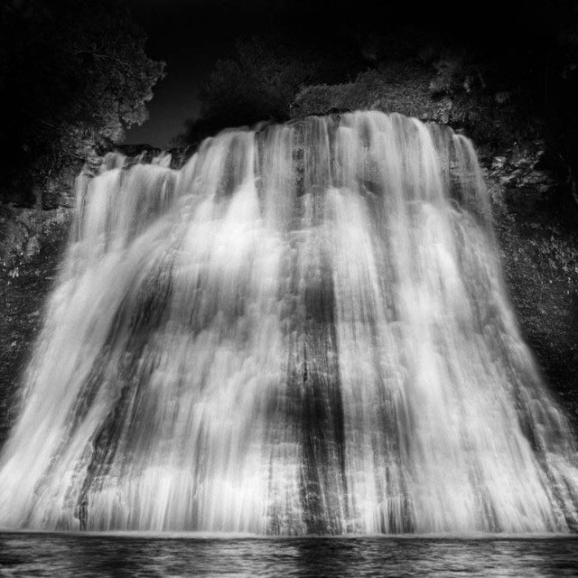 Nighttime - a black and white photograph of a waterfall by John Arnison.