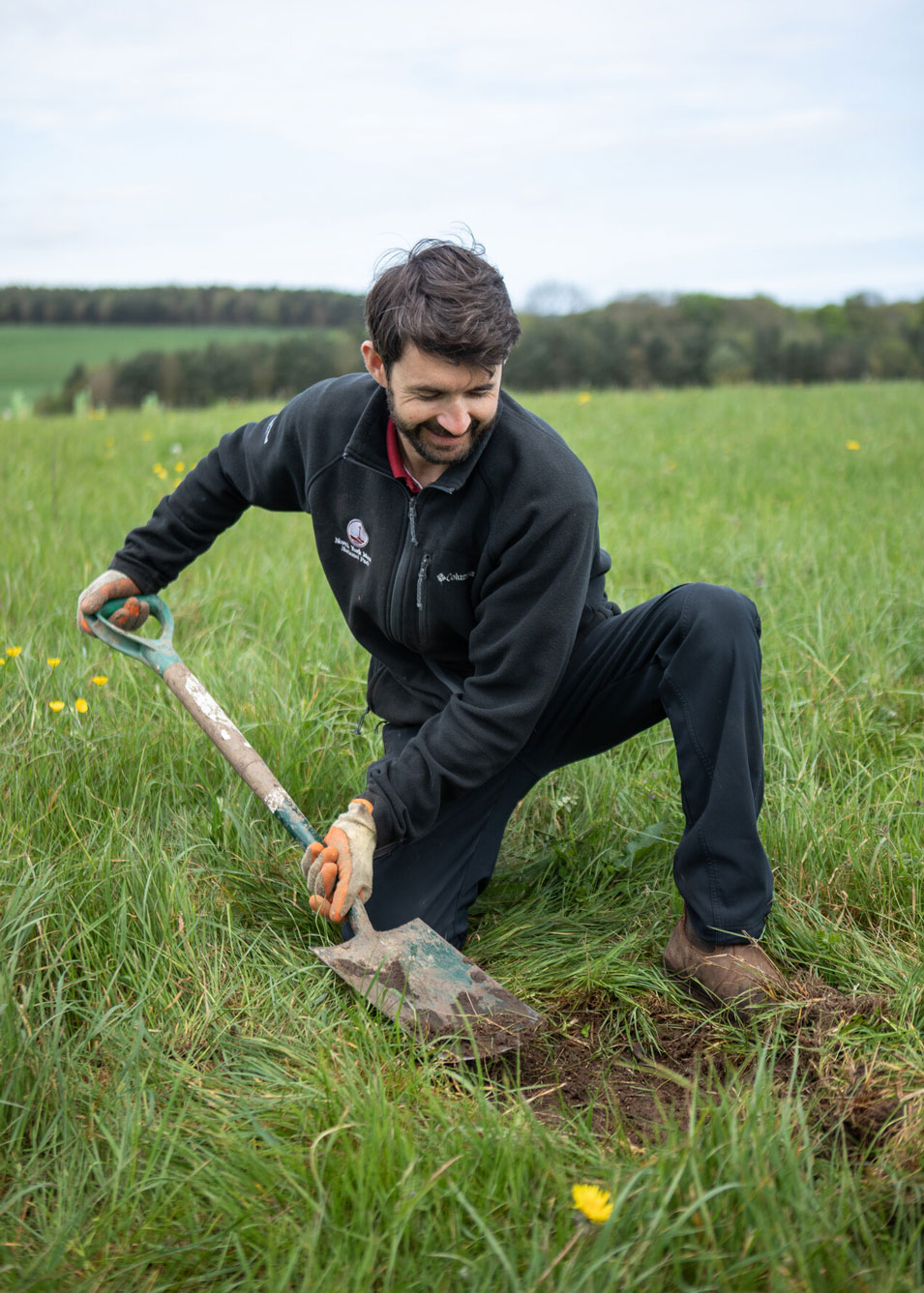 Man digging into soil with a spade in a field. Credit Charlie Fox.